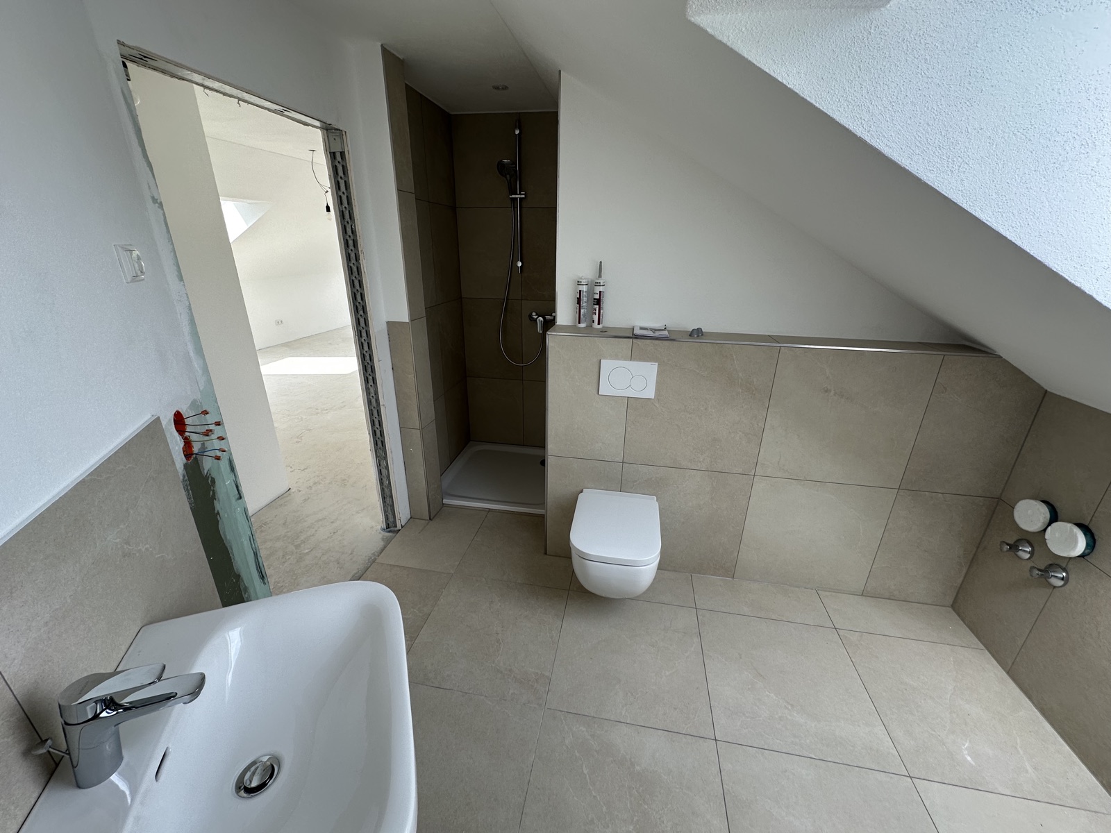Bad mit Dusche und WC unter der Dachschräge in der Dachgeschosswohnung