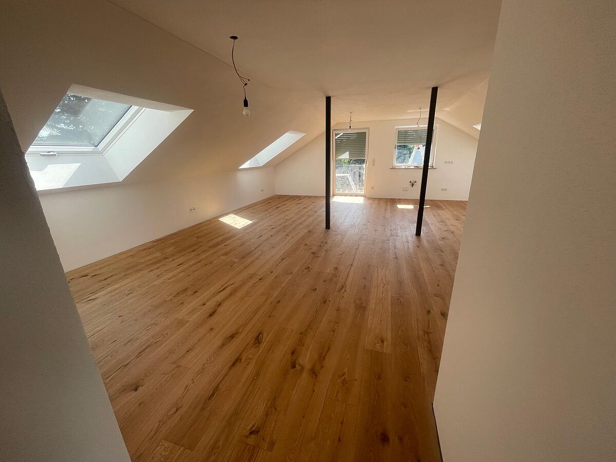 Fertige Dachgeschosswohnung mit Dachfenstern, Eichenparkett und zwei Stahlstützen bei der Übergabe