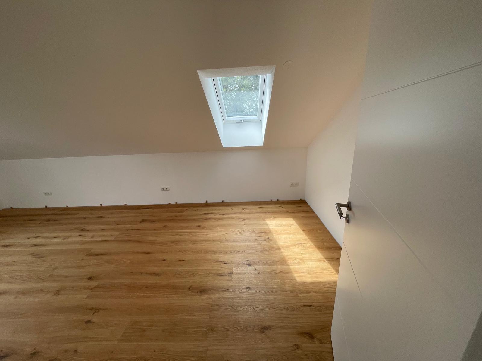 Zimmer mit Dachfenster und Eichenparkett in der ausgebauten Dachgeschosswohnung